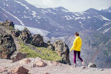 happy free woman in yelllow jacket in summer Elbrus
