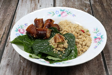 Famous Thai ancient snack menu on the plate. Famous minced fish meat and grilled fish sausage serving with fresh chilly and green vegetable.