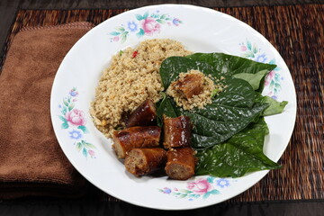 Famous Thai ancient snack menu on the plate. Famous minced fish meat and grilled fish sausage serving with fresh chilly and green vegetable.