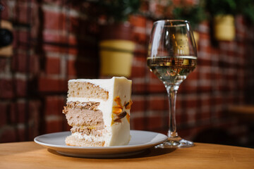 A piece of layer cake and glass of white wine