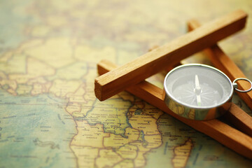Travel and adventure search concept. Vintage aged map with a shabby book and compass. Shabby book and compass on the table.