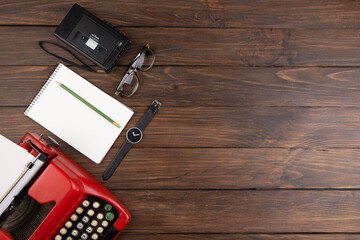 Writer or journalist workplace - vintage red typewriter, cassette recorder and notepad on the...