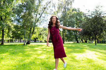 leisure and people concept - happy smiling beautiful woman with long wavy hair walking along summer park