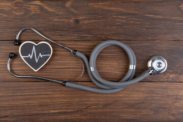 Workplace of a doctor. Stethoscope and little heart on wooden desk background
