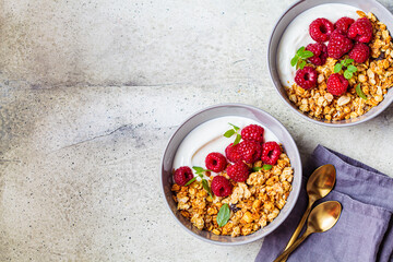 Muesli with raspberries and yoghurt in gray bowl, top view, copy space, Healthy food concept.