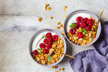 Muesli with raspberries and yoghurt in gray bowl, top view, copy space, Healthy food concept.