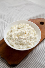 Tasty Ricotta Cheese in a White Bowl, side view. Copy space.