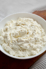 Tasty Ricotta Cheese in a White Bowl, low angle view. Close-up.