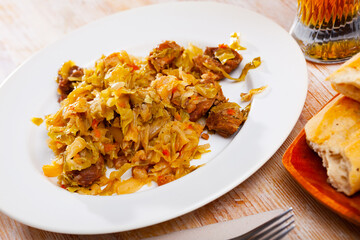 Delicious meat dish - pork with stewed cabbage served on plate. High quality photo