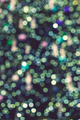 Abstract green bokeh background. Defocused abstract green background. Blurred holiday bokeh. vertical photo