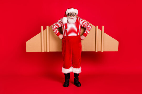 Full length body size view of his he handsome strict bearded Santa father wearing jet air wings celebrate eve noel newyear isolated bright vivid shine vibrant red color background
