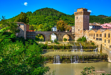 Roman bridge, medieval tower and Metauro river. Fermignano, Marche, Italy.