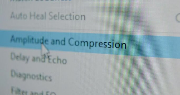 Cursor moves along computer program menu and stops on Amplitude and Compression at working on sound track extreme close view