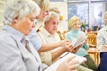 Ärztin oder Therapeutin hilft Senioren beim Schreiben in der Schreibtherapie