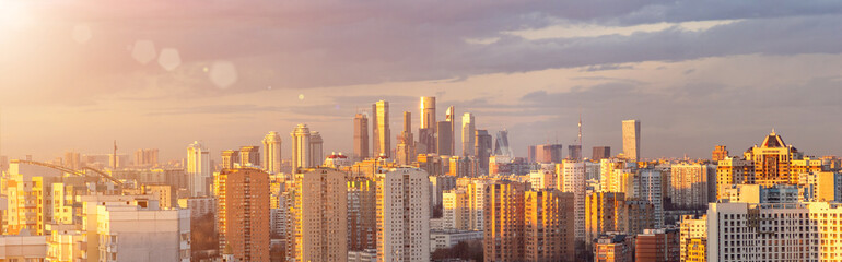 Panorama of Moscow from aerial view at sunset. Cityscape with Moscow City in the distance and modern multi-storey residential buildings in the foreground