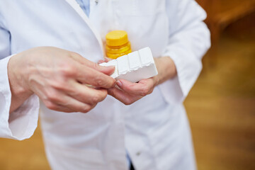 Ärztin mit einem Tablettendispenser und anderen Medikamenten