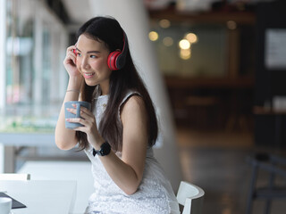 Female relaxing with headphone and coffee cup in co working space