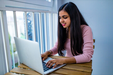 indian woman sitting at home and learning online