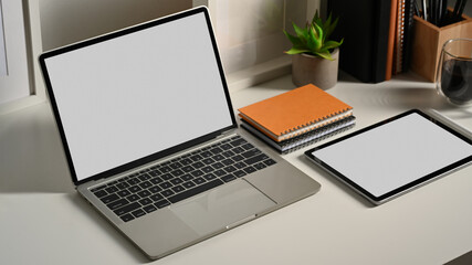 Worktable with tablet, laptop, notebooks and supplies  in office room, include clipping path