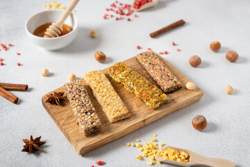 Cereal superfood energy bars with almond nuts, dry fruits, raisins chocolate on a wooden board on white background, side view