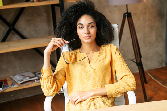 Video chat with attractive african american female colleague. Online meeting with a multi ethnic woman sitting at modern office, listens carefully
