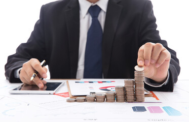 The financial practitioner holds a coin in his hand and continues to stack a row of increasing coins