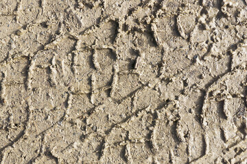 Mud tyre mark background. Wet sand tire print texture. Car trail track pattern. Mountain road after rain. Slippery terrain dangerous weather conditions.