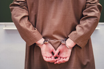 Woman teacher handcuffed, anti-graft concept at school. Education during the coronavirus epidemic