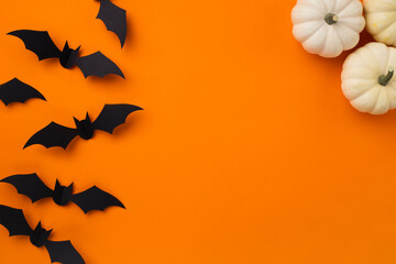 Happy halloween holiday concept. Halloween decorations, pumpkins and bats on orange background