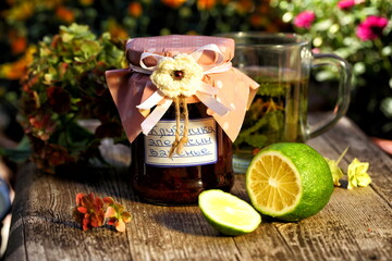 Strawberry jam with orange with tea on wooden background