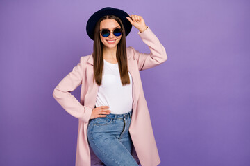 Turned photo of pretty lovely millennial girl touch her retro blue velvet hat enjoy fall weekend holiday free time wear jeans isolated over purple color background