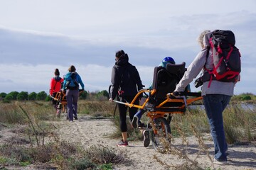 Randonnée solidaire avec handicap en joelette sorte de fauteuil roulant pour aider un handicapé...