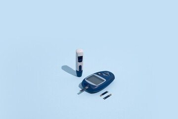 Glucose meter and pen on blue background with shadow, Metabolic syndrome concept