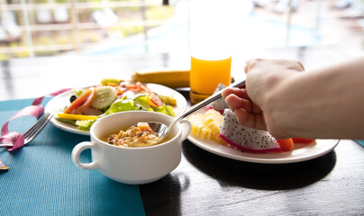 Selective focus of woman hand with Yogurt and fresh of mousse in blow and measuring on wooden background ,diet lifestyle concept