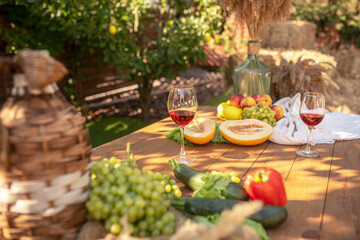 Wooden table with fruit, vegetables and two glasses of red wine