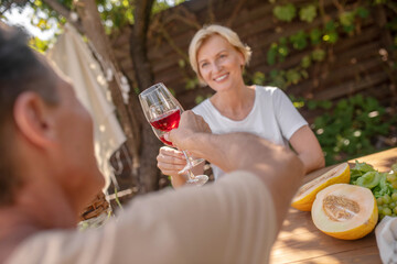 Happy male and female having lunch, toasting outside