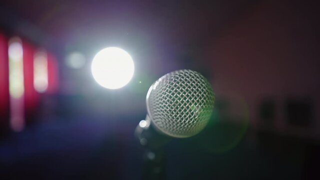 Microphone in bright light. An empty hall without spectators. Concert hall scene. Waiting for the performance of an artist, singer, politician. World crisis, financial losses