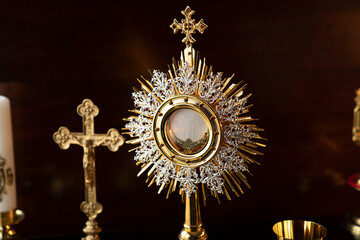 Fototapeta na wymiar Catholic religion concept. Catholic symbols composition: The Cross, monstrance and golden chalice.