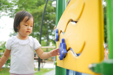 Asian Chinese child trying to play with outdoor game playground in park