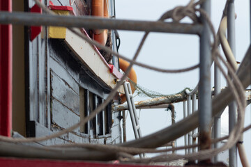 Barco de madera con redes, salvavidas, escaleras de metal 