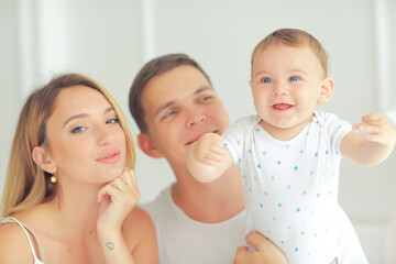 baby with parents in a cozy house / healthy young family mom dad and baby, happiness smile