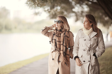 autumn fashion park girls two look / walk in a city park two glamorous fashionable girlfriends in a coat