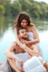 Fototapeta premium beautifulcaucasian family resting on gadgets during self isolation period. wrapped in blankets on the riverbank. enjoy each other, love and laugh
