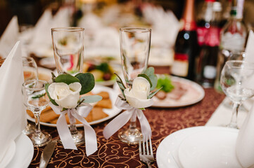 Two Wedding glasses are decorated flowers with ribbons. Close up.