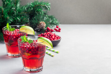 Lingonberry and lime punch or limeade in a glass, christmas tree decoration on background, horizontal, copy space