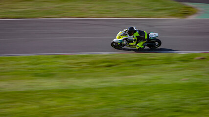 Fototapeta premium A panning shot of a racing bike cornering as it circuits a track.