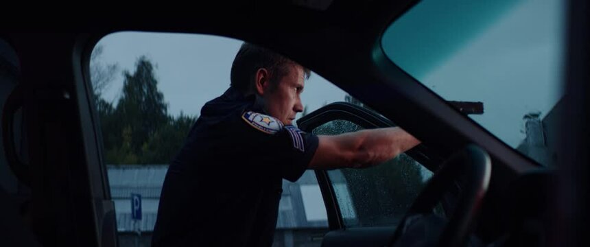 HANDHELD Police officer hiding behind the door and aiming handgun at someone in the street. Shot on RED Dragon with 2x Anamorphic lens