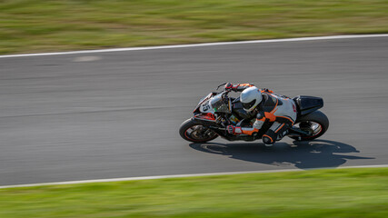 Fototapeta premium A panning shot of a racing bike cornering as it circuits a track.