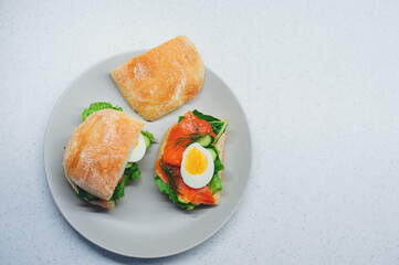 tasty healthy breakfast - smoked salmon chiabatta toast with cucumber, salad and boiled eggs