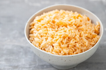 boiled rice with tomato in bowl on ceramic background